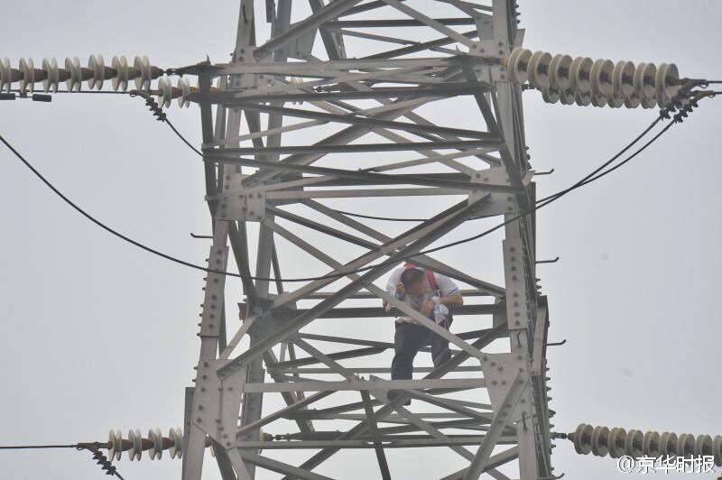 男子爬上北京雍和宫桥边高压塔约30米处